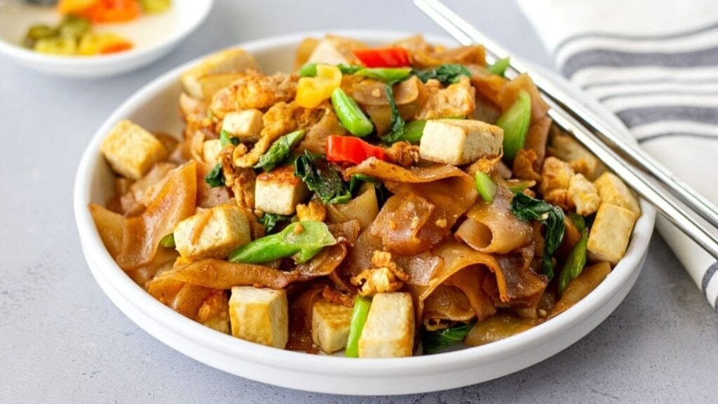 Stir-fried vegan noodles with tofu and Chinese broccoli.