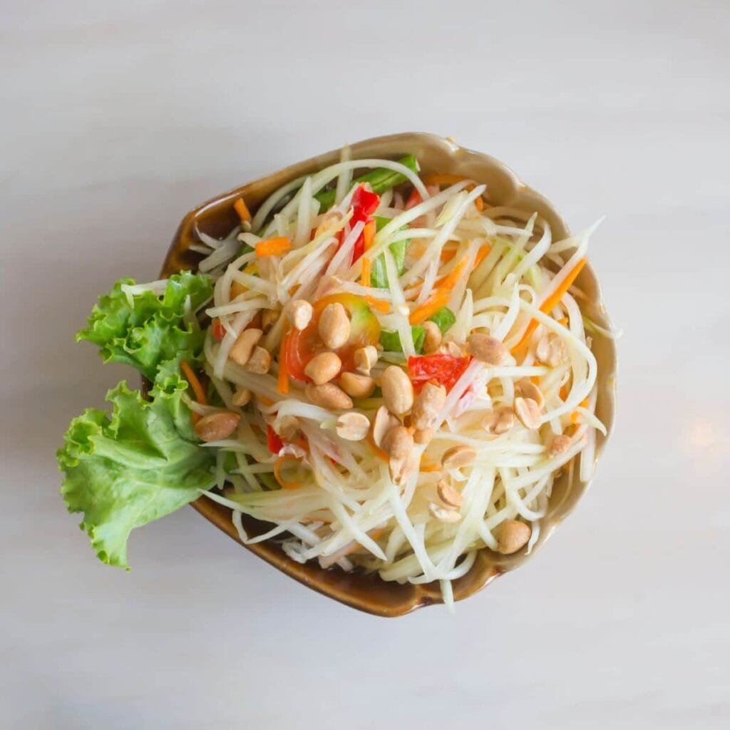 Fresh vegetarian papaya salad made with shredded green papaya and tomatoes